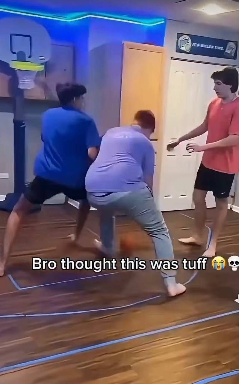 Three players scrambling for the ball on the living-room floor